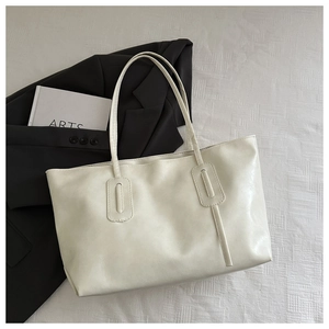 Close-up of cream white tote bag material with rectangular handle reinforcement