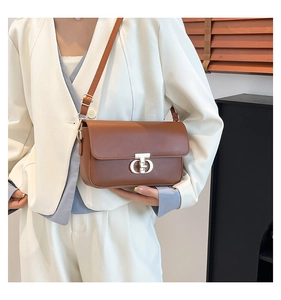 Detailed view of dark brown PU leather crossbody bag with a gold metal clasp and adjustable strap