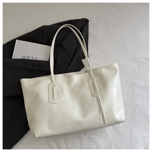 Detail of off-white faux leather tote bag with vertical stitching for daily commute