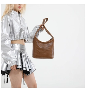 Detailed view of brown woven leather hobo bag with textured pattern on model