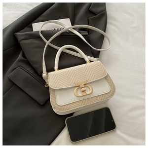 Détail d'un sac à main chic en cuir tressé avec fermoir doré et bandoulière amovible