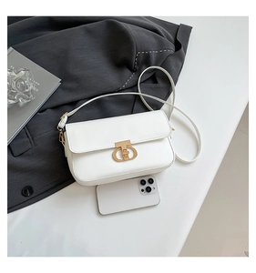 Detail view of mini white PU leather bag with gold T-shaped clasp and smartphone for scale