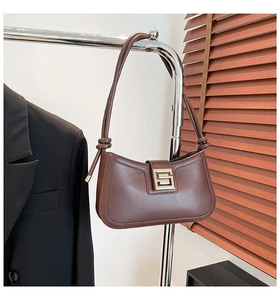 Close-up of brown matte leather bag with silver buckle and stylish knotted shoulder strap