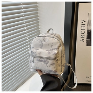 Detail of mini faux leather backpack with purple butterfly prints and front zip pocket