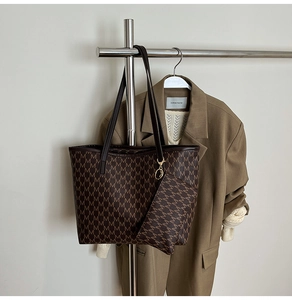 Détail d'un sac cabas marron avec motif logo 'M' imprimé sur similicuir texturé