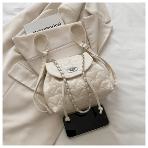 Detail of cream white heart-quilted mini backpack with silver metal twist lock and drawstring