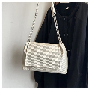 Detail of cream white shoulder bag featuring premium diagonal textured pattern and chain strap