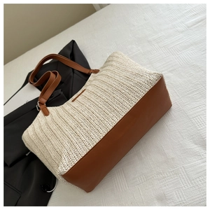 Close-up of the woven V-shaped texture and brown leather trim on a summer straw tote bag