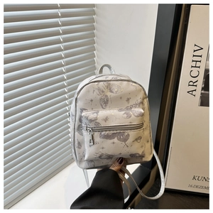 Detailed view of mini grey backpack with butterfly print and silver zipper closures