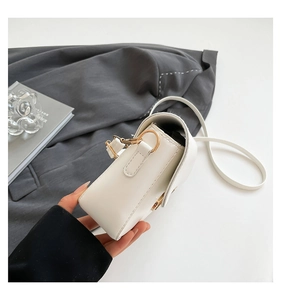 Detailed close-up of a white PU leather crossbody bag featuring minimalist gold metal hardware