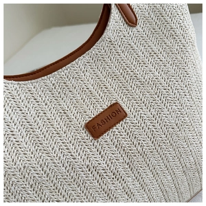 Detailed macro view of woven straw texture with a brown leather logo patch and stitching