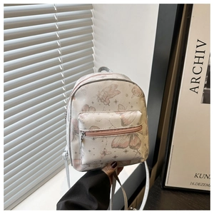 Detail of a beige PU leather mini backpack with pink butterfly and gold star patterns