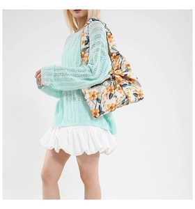 Close-up of floral quilted tote bag featuring a bow detail and colorful flower prints