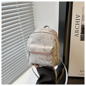 Close-up of the mini backpack featuring pink butterfly patterns and star details
