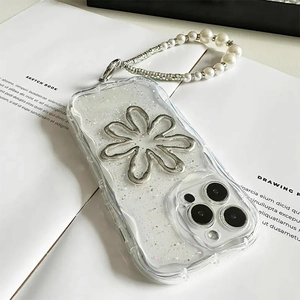 Nahaufnahme der Glitzer iPhone Hülle mit silberner Blume und Perlen-Handgelenkschlaufe