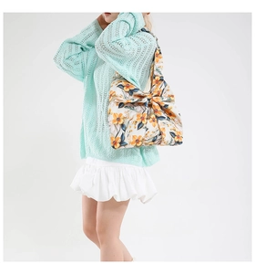 Close-up of floral print cotton handbag featuring a large decorative knot detail on the side