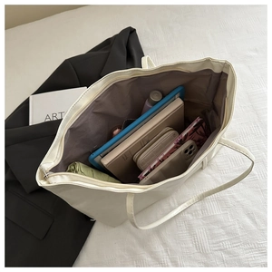 Internal view of beige tote bag showing large capacity for laptop and daily items