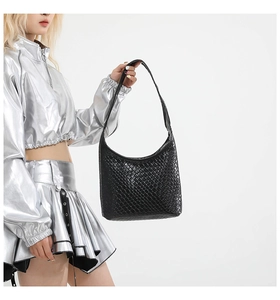 Close-up of black woven leather texture and hobo shoulder bag strap detail