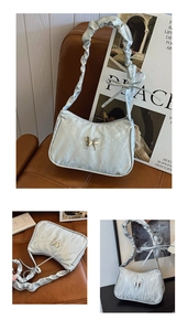 Detail of light blue pleated shoulder bag featuring a silver butterfly clasp and bow strap