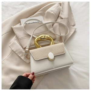 Detail of woven flap handbag with artistic gold lava handle and white leather texture