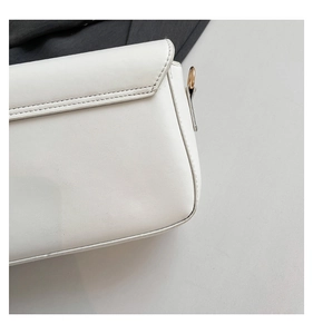 Close-up of white PU leather bag detailing fine grain texture and gold metal ring