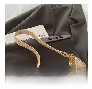 Detailed close-up of beige monogram shoulder bag with gold chain and comfortable handle