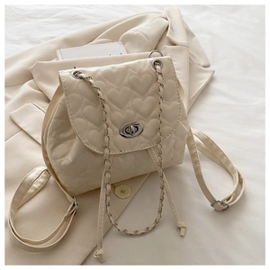 Detail of cream mini backpack featuring heart-shaped quilting and silver twist lock