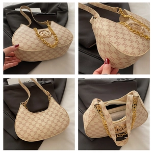 Detail view of beige monogram saddle bag featuring gold chain and metallic M-logo buckle