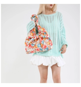 Detailed view of floral tote bag with large 3D bow and vibrant petal textures