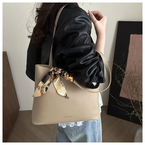 Detail of beige tote bag with chic vintage printed scarf handle for office styling