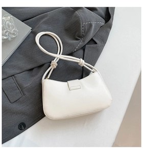 Detail of off-white leather shoulder bag featuring unique knotted rope strap design