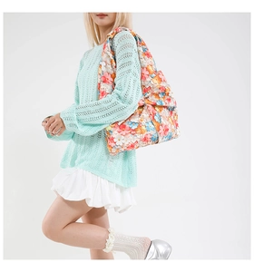 Detailed view of floral shoulder bag featuring a large decorative bow on the side