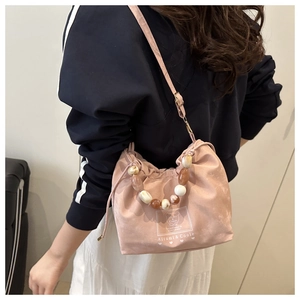 Détail du sac à main rose à cordon avec poignée en perles et impression graphique blanche