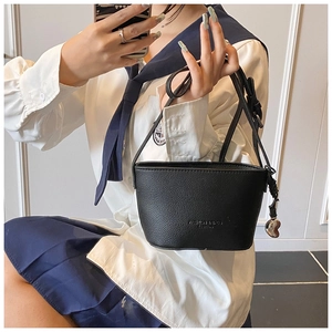 Close-up of black litchi pattern bucket bag with metal heart charm and long strap