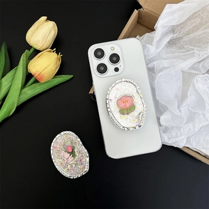 Detail shot of a glittery pink rabbit and tulip phone grip holder on a white smartphone