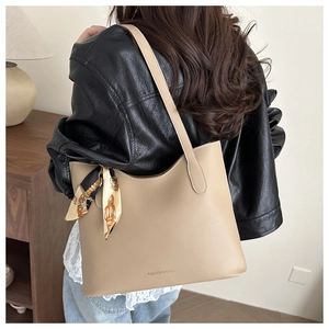 Détail d'un grand sac cabas beige minimaliste avec foulard en soie et lettrage chic