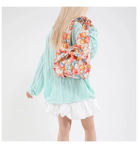 Detailed view of floral shoulder bag featuring a large decorative bow and colorful print