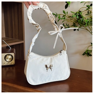 Detail of white pleated underarm bag with silver butterfly buckle and bow shoulder strap