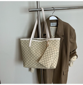 Détail d'un ensemble cabas beige avec imprimé monogramme M et petite pochette assortie