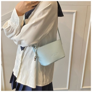 Close-up of light blue lychee pattern bucket bag with silver bear charm and logo