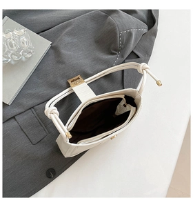 Detail view of white underarm bag showing brown lining and secure inner zipper pocket