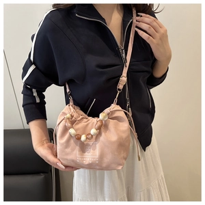 Détail du sac seau rose à cordon avec poignée en perles marbrées et motif d'ours