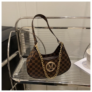 Close-up of brown crescent underarm bag with M-pattern monogram and gold metal buckle