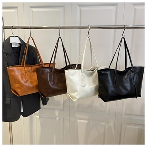 Detail of four bucket bags in various colors featuring refined oil-tanned faux leather
