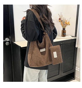 Detail of dark brown corduroy tote and pouch set showing ribbed texture and fabric label