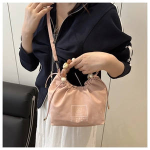 Vue détaillée du sac à main rose perlé avec fermeture à cordon et poignée élégante
