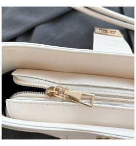 Close-up of the smooth golden zipper detail and premium inner lining of the white bag