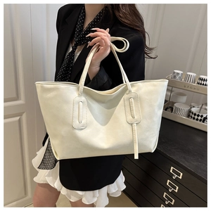 Detailed view of white faux leather tote bag with minimalist strap accents and stitching