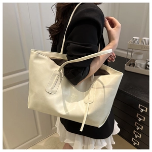 Macro detail of creamy beige PU leather tote bag showing fine texture and vertical stitching