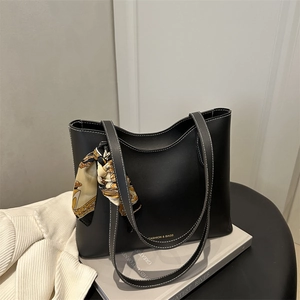 Minimalist black tote bag with white contrast stitching and a vintage patterned silk scarf